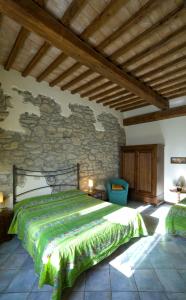 ein Schlafzimmer mit einem großen Bett und einer Steinmauer in der Unterkunft Agriturismo San Giorgio in Orvieto