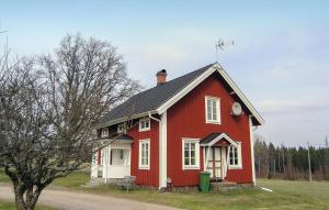 uma casa vermelha com um telhado preto em Cozy Home In Hestra With Kitchen em Valdshult