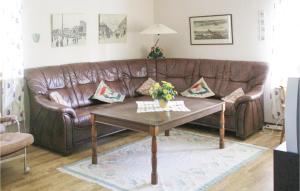 a brown leather couch in a living room with a coffee table at Two-Bedroom Holiday Home In Rottne in Rottne