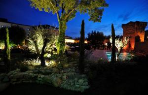 a garden at night with trees and lights at Aquabella Hôtel & Spa in Aix-en-Provence