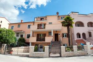 un edificio con una palmera delante de él en Apartments Vidaković en Rovinj