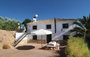 une maison blanche avec une table et un parasol dans l'établissement Beautiful Home In Sileras-almedinilla With Kitchenette, à Almedinilla