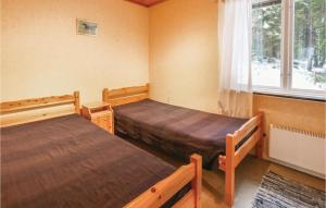a bedroom with two beds and a window at Beautiful Home In Fegen With House Sea View in Fegen