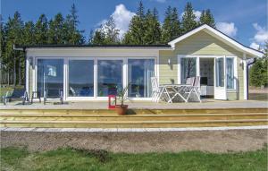 a house with a deck with a table and chairs at Lovely Home In Bolmsö With Kitchen in Bolmsö