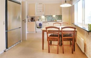a kitchen with a table and chairs and a refrigerator at Beautiful Home In Fegen With House Sea View in Fegen
