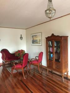 a living room with red chairs and a piano at Fortunata Chacana Guest House in Valparaíso