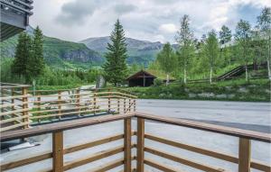 a wooden fence in front of a road with mountains at Beautiful Apartment In Hemsedal With House A Mountain View in Hemsedal