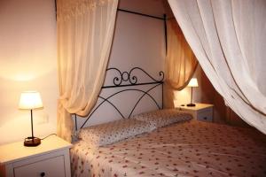 a bedroom with a bed with two lamps and curtains at La Codarda country house in Pescosolido
