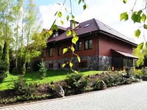 a red brick house with a brick driveway in front of it at Pod Brzozą in Bydlino