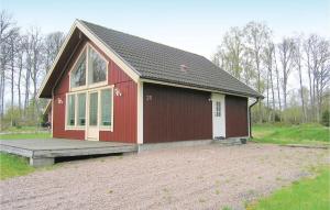 a small red house with a porch and a field at 2 Bedroom Gorgeous Home In Bolms in Bolmsö