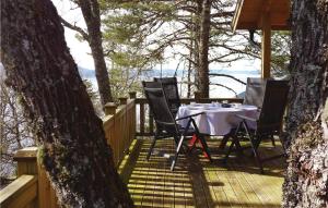 a table and chairs on a deck in the woods at Bjrgan Grd in Vannvikan