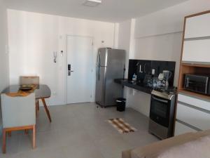 uma cozinha com um frigorífico de aço inoxidável e uma mesa em Apartamento de alto luxo. em Maceió