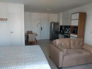a room with a bed and a couch and a kitchen at Apartamento de alto luxo. in Maceió