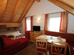 salon z czerwoną kanapą i stołem w obiekcie Quaint Apartment in L ngenfeld with Sauna w mieście Huben