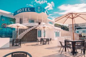 埃斯梅拉達斯的住宿－Hotel Casa Arnaldo "Esmeraldas"，配有桌椅和遮阳伞的酒店