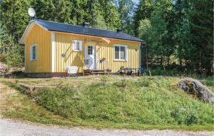 a yellow tiny house in the middle of a field at Beautiful Home In Fegen With House Sea View in Fegen