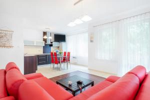 a living room with a red couch and a table at Apartamenty Morskie Oko by Renters in Międzyzdroje