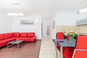 a living room with a red couch and a table at Apartamenty Morskie Oko by Renters in Międzyzdroje