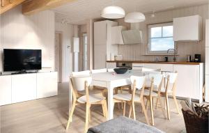 a kitchen and dining room with a white table and chairs at Awesome Home In Zerpenschleuse With Kitchen in Zerpenschleuse