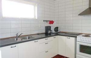 LöttorpにあるStunning Home In Lttorp With 2 Bedroomsの白いキャビネット、シンク、窓付きのキッチン