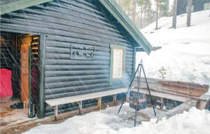 a log cabin with a bench in the snow at 4 Bedroom Stunning Home In Rendalen in Rendalen