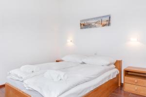 a bed with white sheets and towels on it at Apartamenty Morskie Oko by Renters in Międzyzdroje