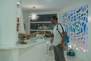 a man and woman standing at a counter in a store at Hotel Casa Arnaldo "Esmeraldas" in Esmeraldas
