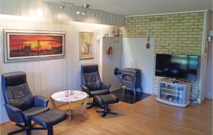 een woonkamer met een tv en stoelen en een tafel bij 3 Bedroom Lovely Home In Fjra in Fjæra