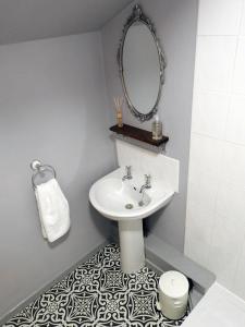 a bathroom with a sink and a mirror at Heatopia Apartment in Newcastle upon Tyne