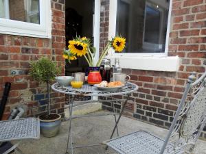 uma mesa com comida e um vaso com girassóis em Heatopia Apartment em Newcastle upon Tyne