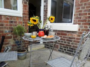 a table with food and a vase with sunflowers at Heatopia Apartment in Newcastle upon Tyne