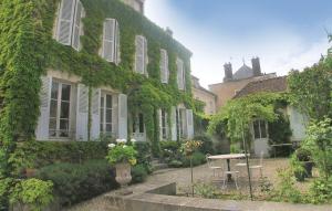 an ivy covered building with a table in front of it at Cozy Home In Chablis With Wifi in Chablis