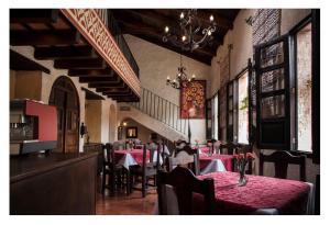 a restaurant with tables and chairs with red table cloth at Posada El Antaño in Antigua Guatemala