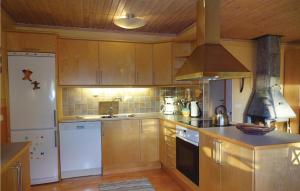 TorsöにあるAwesome Home In Torsö-Sölvesborgの木製のキャビネットと白い冷蔵庫を備えたキッチン
