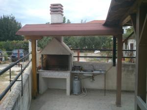 an outdoor oven with a roof on a patio at Kalaitzis Apartments in Kalivia Poligirou