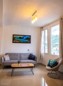 San Pedro Suite في سان بيدرو لا لاغونا: غرفة معيشة مع أريكة وطاولة