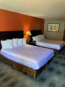 a hotel room with two beds in a room at Pepper Tree Inn in Beaverton