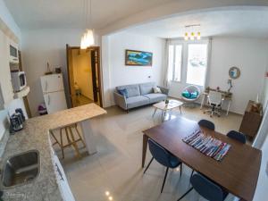 San Pedro Suite في سان بيدرو لا لاغونا: مطبخ وغرفة معيشة مع طاولة وأريكة