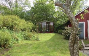 a garden with a greenhouse in the back of a house at Nice Home In Kvidinge With Wifi in Kvidinge