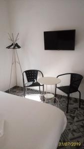 Habitación con sillas, mesa y TV. en Vila Algarvia Boutique & Suites, en Albufeira