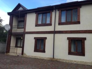 een wit gebouw met bruine ramen op een straat bij Royal Hotel in Charkov