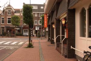 una strada cittadina con marciapiede in mattoni accanto a un edificio di CoronaZeist-Utrecht NL a Zeist