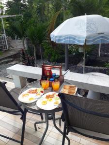 a table with two plates of food and an umbrella at Belinda Home in Ko Si Chang