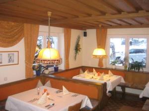 a dining room with two tables in a restaurant at Pension Klausnerhof in Brixen im Thale