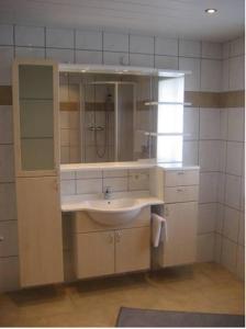uma casa de banho com um lavatório e um espelho em Pension Klausnerhof em Brixen im Thale