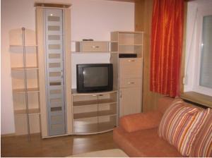 uma sala de estar com um quarto com uma televisão em Pension Klausnerhof em Brixen im Thale