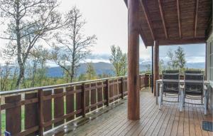 a wooden deck with a table and chairs on it at Amazing Home In Hol With Sauna in Seim