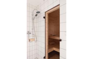 a bathroom with a shower with white tiles at Cozy Home In Gammelby With Sauna in Gammelby