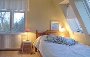 a bedroom with a bed and two windows at Stunning Home In Degerhamn With Wifi in Gammalsby
