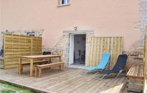 a wooden deck with two chairs and a table at Cozy Home In Sainteny With Kitchen in Sainteny +6 photos